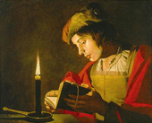 Young man reading by candlelight